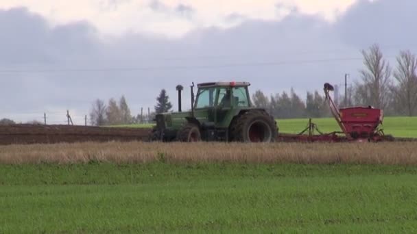 Tractor con sembradora en campo — Vídeos de Stock