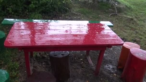 Autumn evening rain drops on red table — Stock Video