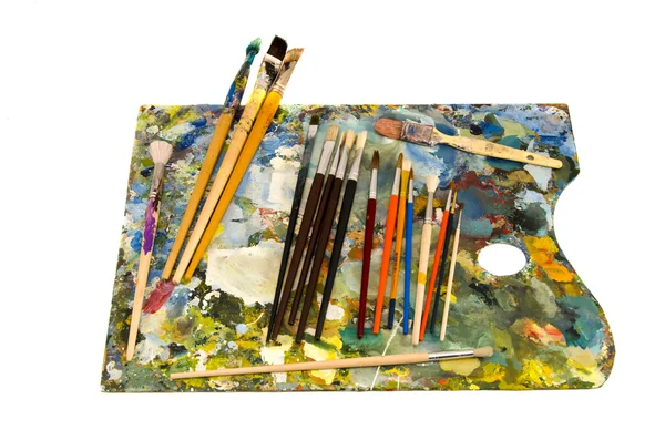 Oil painters palette with brushes on white — Stock Photo, Image