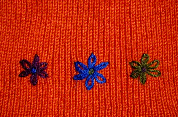 Knited wool background with flower symbols — Stock Photo, Image