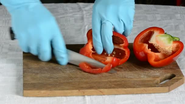 Skär upp röd paprika på bordet — Stockvideo