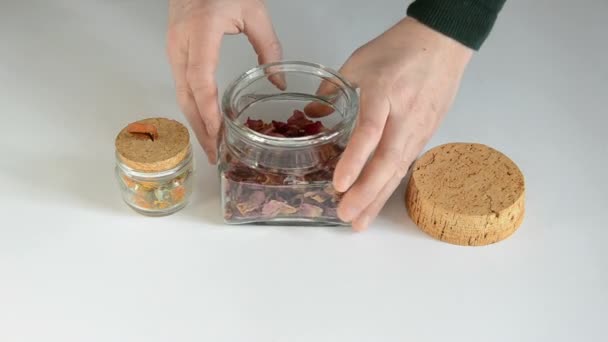 Dry brier blow tea on table and glass jar — Stock Video