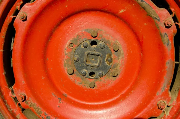 Farm tractor wheel detail red metal background — Stockfoto