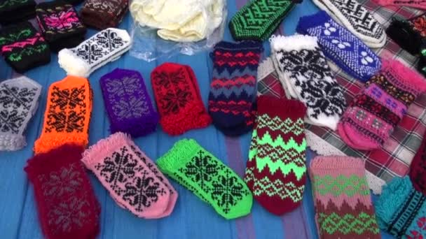 Assorted handmade knitted mittens collection in fair — Stock Video