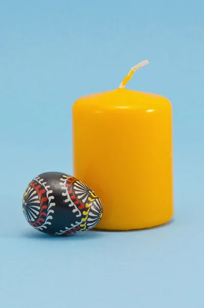 Uovo di Pasqua in legno dipinto e candela gialla — Foto Stock