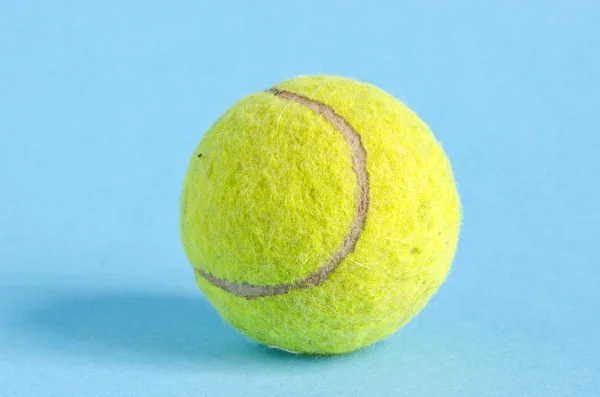 Una pelota de tenis sobre fondo azul — Foto de Stock