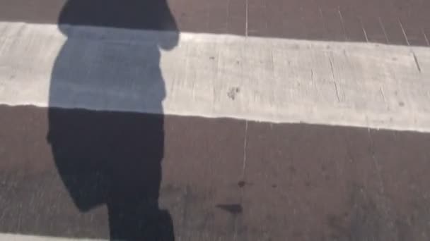 Hommes ombre marche sur zèbre traversant en ville — Video