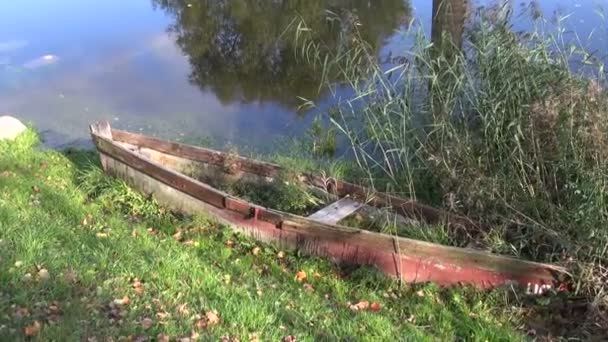 Kaputtes Holzboot in der Nähe des Herbstflusses — Stockvideo
