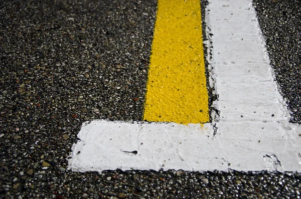 Wet asphalt with white and yellow lines — Stock Photo, Image