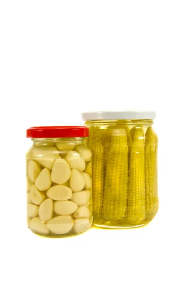 Pickled garlic and corn cobs in glass jar — Stock Photo, Image