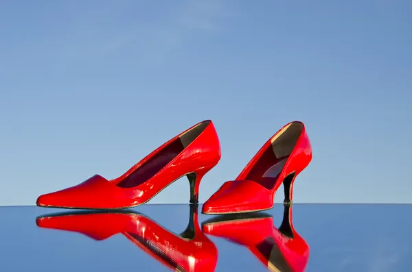 Par de stiletto rojo en el espejo y retrocesos — Foto de Stock