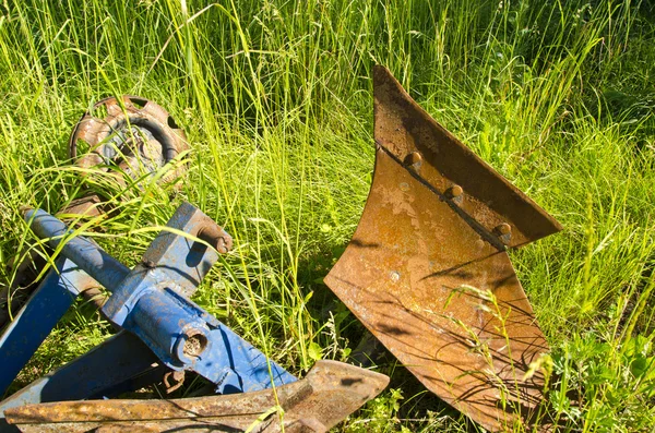 Oude roestige trekker ploegen op gras in boerderij — Stockfoto