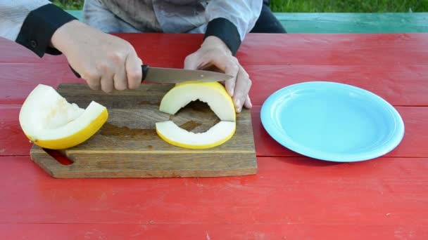 Gelbe Melone auf rotem Tisch zerkleinern — Stockvideo