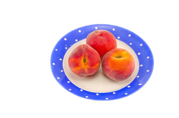 Three peach in blue plate isolated on white — Stock Photo, Image