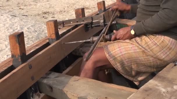 Indio trabajador con primitivo taladro perforación nuevo barco madera — Vídeo de stock