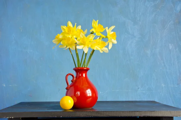 Νάρκισσος άνοιξη στο κόκκινο vase και κίτρινη μπάλα — Φωτογραφία Αρχείου