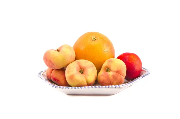 Fresh peaches and grapefruit in plate isolated — Stock Photo, Image