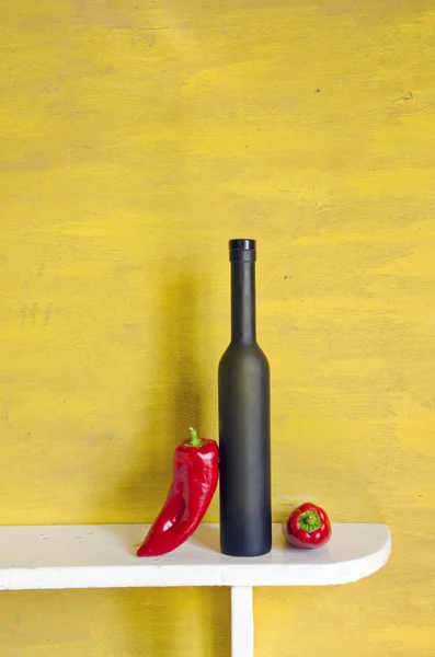 黑葡萄酒瓶和红辣椒 — 图库照片