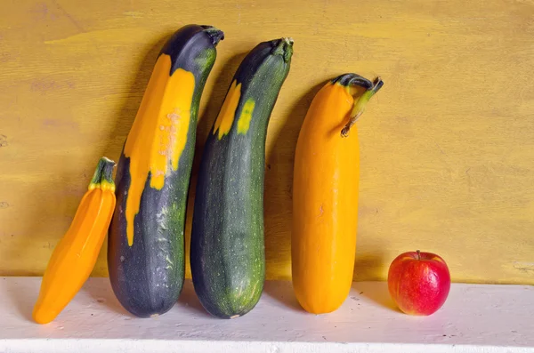 Green and yellow zucchini and red apple — Stock Photo, Image