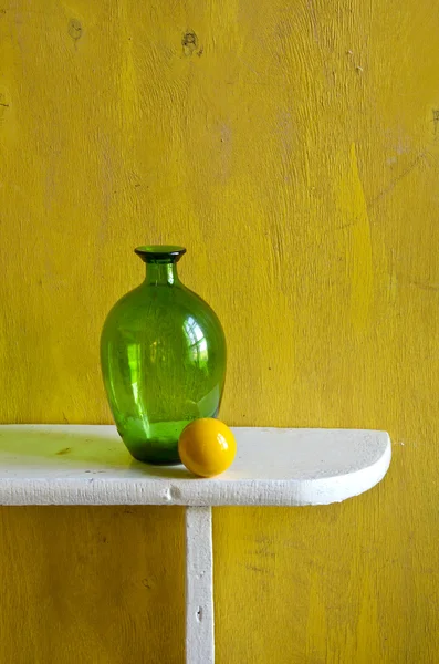 Bodegón con botella verde y bola amarilla — Foto de Stock