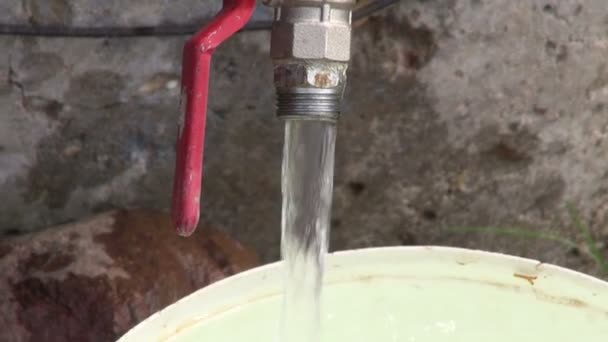 Water uit goed kraan gevuld plastic emmer — Stockvideo