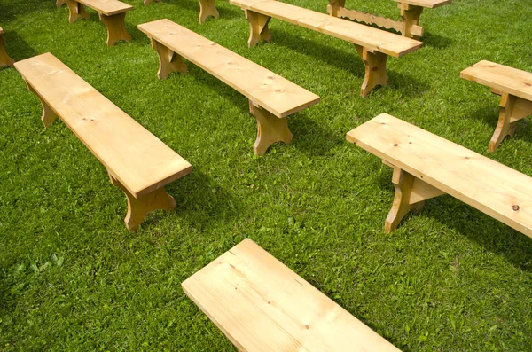 Nouveaux bancs en bois sur herbe dans le parc — Photo