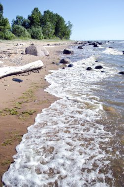 empty summer resort beach with stones and waves
