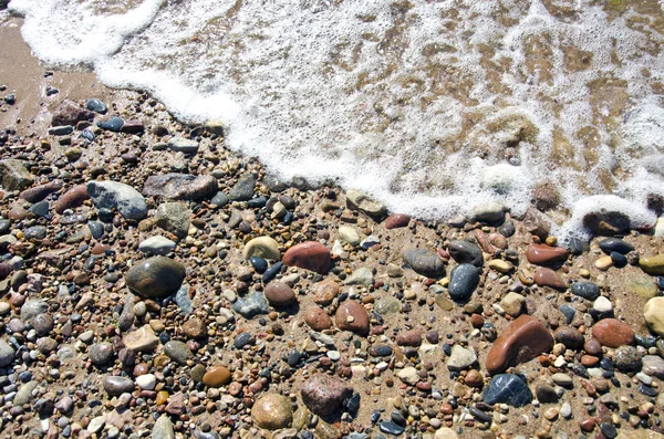 Tengeri nyári homokos strand háttér-kövek és a hullám — Stock Fotó