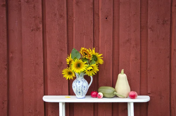 Jarra con girasoles y frutas en el estante — Foto de Stock