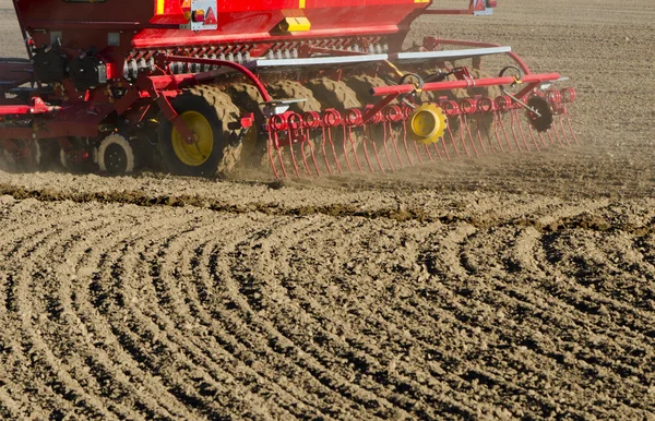 Nueva maquinaria de sembradora de cereales de agricultura que trabaja en el campo — Foto de Stock