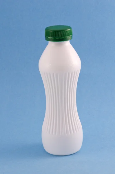 Garrafa de kefir ou leite yougurt no fundo azul — Fotografia de Stock