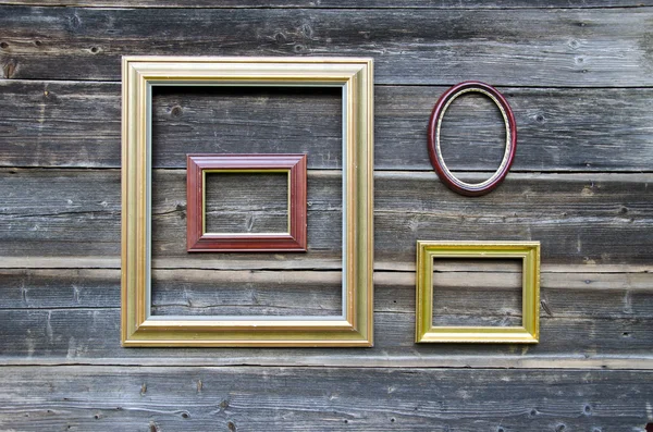 Various picture frame on old wooden wall — Stock Photo, Image