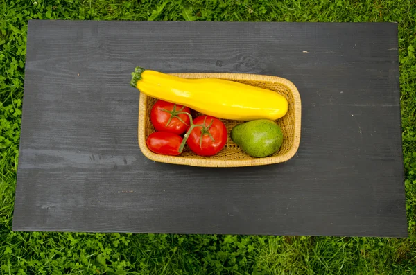Zelenina v dřevěné desky na černém stole — Stock fotografie
