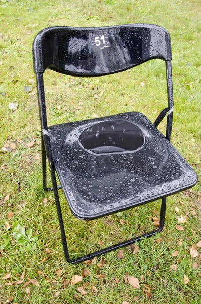 Silla de plástico en el césped del parque después de la lluvia con gotas —  Fotos de Stock