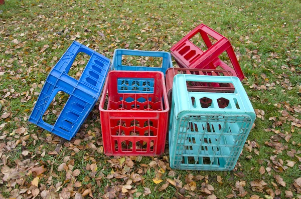 Corlorful plastic boxes for beer bottles on autumn meadow — Stock Photo, Image