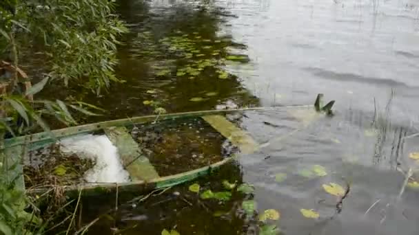Старая деревянная утонувшая лодка в озере после шторма — стоковое видео