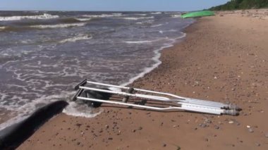 Çift koltuk değneği üzerinde deniz sahil kumu