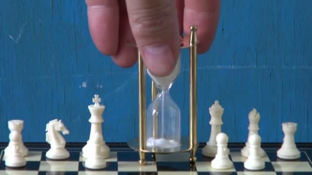 Verre de sable sur échiquier et échecs blancs — Video