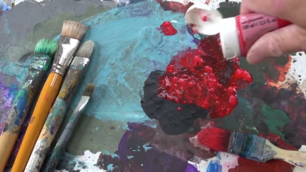 Палитра художников с красной краской и кистью — стоковое видео