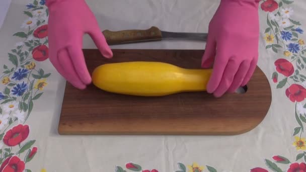 Hand mit Handschuh, der frische gelbe Zucchini schneidet — Stockvideo