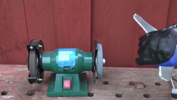 Sharpening grass cutter lawn mower trimmer  blade on stone — Stock Video