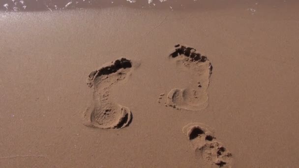 Следы на курортном песке и морских волнах — стоковое видео