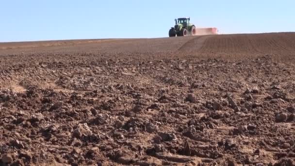 Tractor agrícola con máquina sembradora de semillas y campo de cultivo — Vídeo de stock
