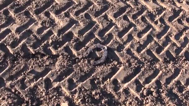 Herradura oxidada histórica y rastros de tractores agrícolas en el suelo — Vídeos de Stock