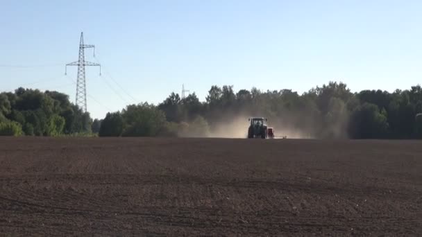 Landbouw trekker zaaiend zaden op boerderij veld — Stockvideo