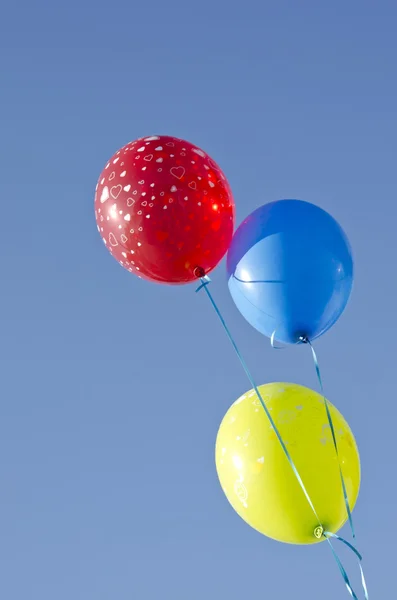 Mavi gökyüzü üzerinde üç renkli balonlar — Stok fotoğraf