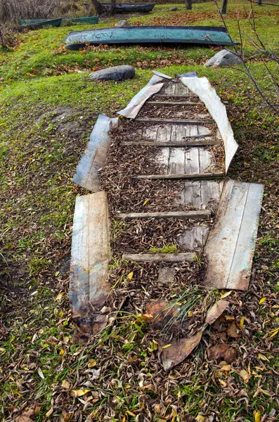 Разбитая старая лодка на осеннем берегу реки — стоковое фото