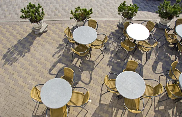 Mesas y sillas en el café de la calle en el pavimento — Foto de Stock