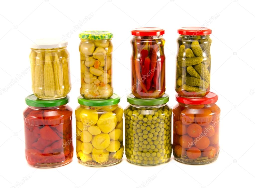 Collection various canned vegetables in glass jars isolated on white