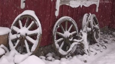 Konut ve kış kar düşen yakınındaki eski at arabası tekerlekler